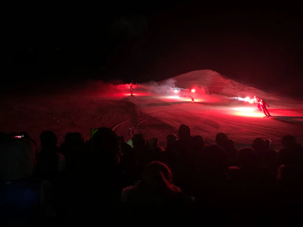 Rote Bengalfeuer auf der nächtlichen Piste.